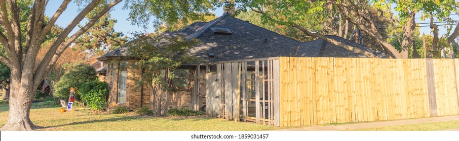 Panoramic View New Wooden Fence Near Collapsed Aged Slats In Backyard And Front Yard Of Residential House With Tall Trees In Suburban Dallas, Texas, USA. Installation Boards Lumbers Of Corner House