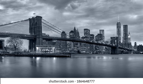 panoramic view new york city downtown manhattan skyline at night with skyscrapers and brooklyn bridge - Powered by Shutterstock