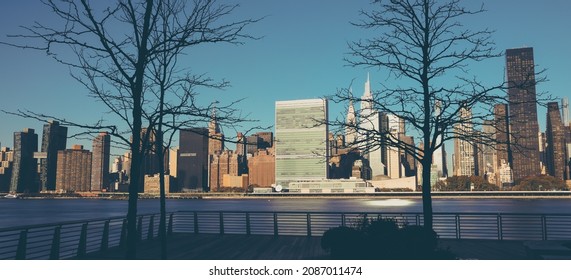 Panoramic View Of New York City Skyline With United Nations Headquarters Seen From The East River At Sunrise. Manhattan Midtown Skyscrapers With Iconic UN Secretariat And General Assembly Buildings.