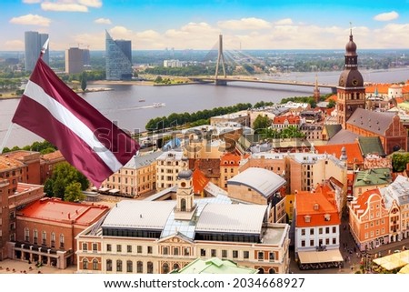 Panoramic view of the old city of Riga, Latvia from the tower Church of St. Peter with Latvia flag. Summer sunny day.