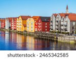 Panoramic view of old colorful wooden houses with reflections in river in Trondheim, Norway