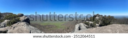 
A panoramic view from Old Rag Mountain reveals the stunning Shenandoah Valley below. Rolling hills, forests, and distant peaks stretch out under a vast sky, capturing the serene beauty of the landsca