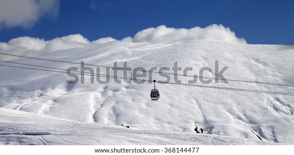 Panoramic view on gondola lift\
and ski slope at sun day. Caucasus Mountains, Georgia, region\
Gudauri.