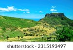 Panoramic view on massive volcanic plug Fortaleza de Chipude overlooking western coast of La Gomera, Canary Islands, Spain, Europe. Village in valley embedded lush green hills. Road to Valle Gran Rey