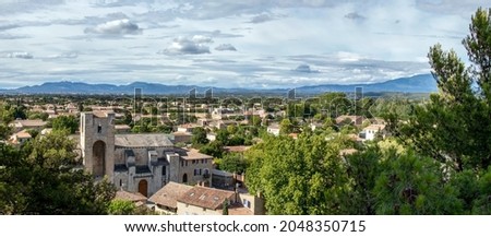 Panoramic view on the Pernes les Fontaines, small typical town of Provence, with red tailed rooftops, church, and mountain range on the background, Vaucluse, France, Europe