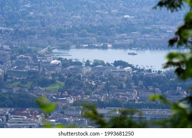 Panoramic view over City of Zurich with lake Zurich seen from local mountain Uetliberg on a hazy summer day. Photo taken June 18th, 2021, Zurich, Switzerland.