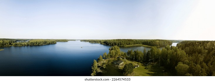 Panoramic view over forest lake with a lakeside cabin a clear summer day in Sweden - Powered by Shutterstock