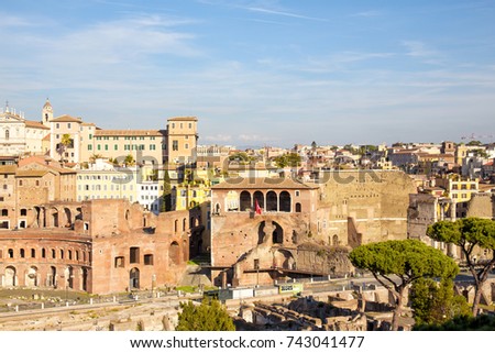 Panoramic view over the old city of Rome beautifully lit by an afternoon sun and set against a blue sky.