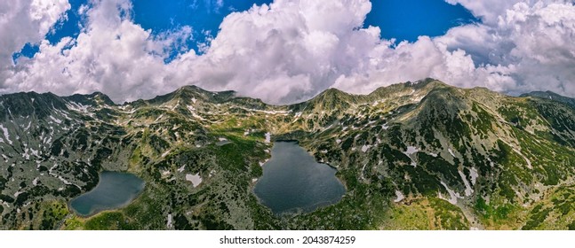 Panoramic view over Retezat mountains, Romania with lakes and mountain peaks, shot from a drone at high altitude. Mountain range with lakes and peaks panorama