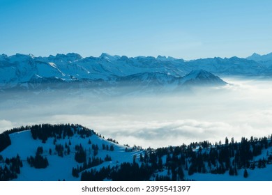 Panoramic view over summit of Mount Rigi (Rigi Kulm) and Lake Lucerne underneath, Switzerland. Amazing snow and fog covered Swiss alps mountain peaks and winter scenery landscape.
