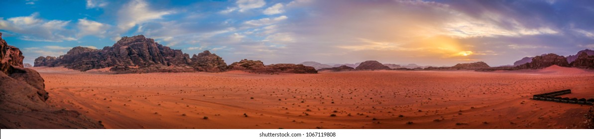 Panoramic view overlooking the red sand desert and Bedouin camp as seen with a cloudy golden sunset in Wadi Rum, Jordan
 - Powered by Shutterstock