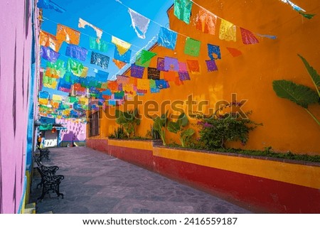 panoramic view of a picturesque street in the town of Zimapán decorated with colorful pennants on a sunny day