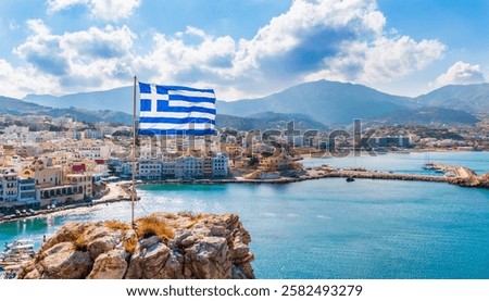 Panoramic view of Pigadia bay, town and harbor with Greek flag, Karpathos Island, Greece