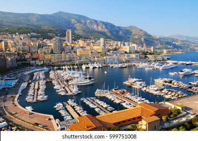 Panoramic view of port of Hercules with luxury yachts and ref roofs of buildings in La Condamine district in Monaco.