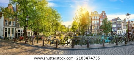 Panoramic view of a quiet morning Amsterdam. Houses, bridges, bicycles - old Amsterdam. Lovely morning in Amsterdam. Holland, Netherlands, Europe.