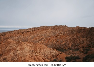 Panoramic view of red sandstone formations in Skazka Canyon, also known as Fairy Tale Canyon, located near Issyk-Kul Lake in Kyrgyzstan.