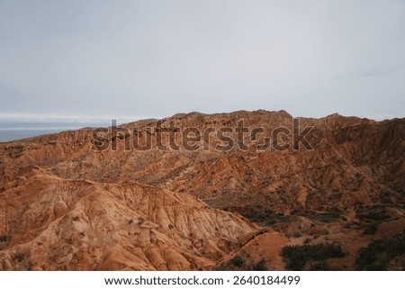 Panoramic view of red sandstone formations in Skazka Canyon, also known as Fairy Tale Canyon, located near Issyk-Kul Lake in Kyrgyzstan.