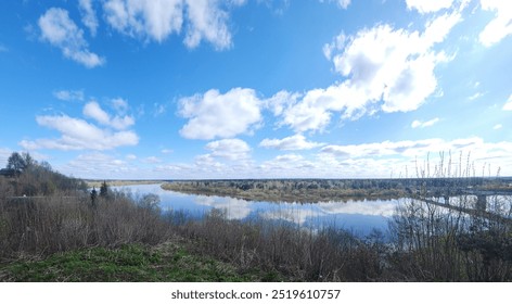 Panoramic view of river bend, forest and blue sky. Beautiful reflection of white clouds in water at sunny day. Aerial view of picturesque background. High quality photo - Powered by Shutterstock