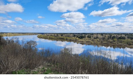 Panoramic view of river bend, forest and blue sky. Beautiful reflection of white clouds in water at sunny day. Aerial view of picturesque background. High quality photo - Powered by Shutterstock