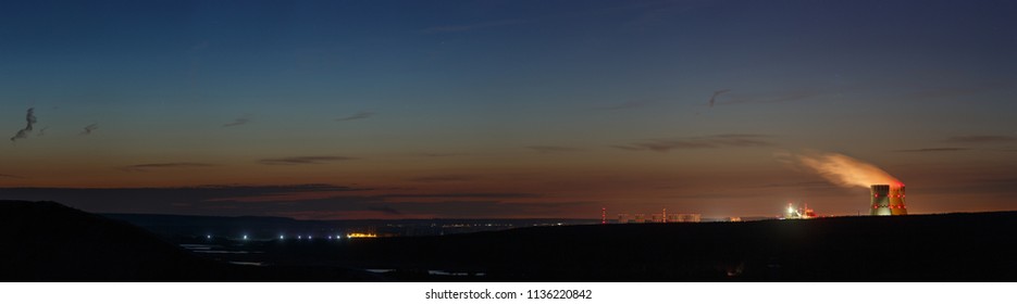 Panoramic view of the river valley with a nuclear power plant. Landscape after sunset, the twilight sky.