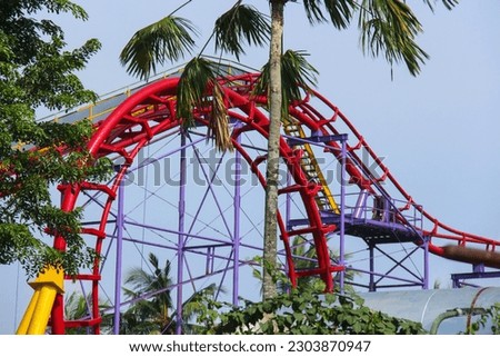 Panoramic view of a rollercoaster ride with sharp turns and twists on a sunny summer evening in Dufan, Dunia Fantasi, Fantasy World, Jakarta Indonesia