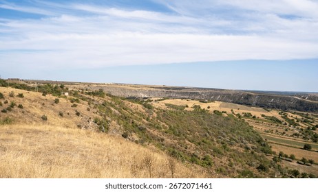 A panoramic view of rolling hills and fields under a bright blue sky, showcasing the beauty of nature.