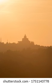 Panoramic view of San Luca Sanctuary at the sunset, with orange sky and sun in the background. There is the wood of the Bologna's hills ( colli bolognesi). Emilia Romagna Region.