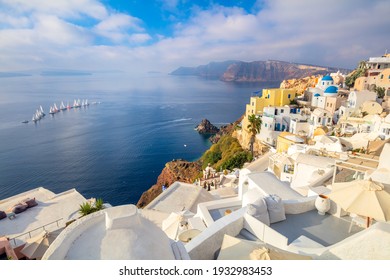 Panoramic view of Santorini. The famous town of Oia in the morning. A line of sailing yachts at sea. Good vacation. Oia, Santorini, Greece