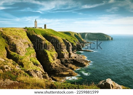 Panoramic view of scenic coastal landscape with traditional lighthouse at famous Cap Frehel peninsula on the Cote d'Emeraude, commune of Plevenon, Cotes-d'Armor, Bretagne, northern France