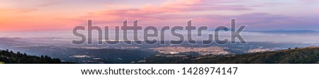 Panoramic view of Silicon Valley and the San Francisco bay area at sunset; Stanford University, Menlo Park, Mountain View, Redwood City, Foster City and Palo Alto visible under a layer of clouds