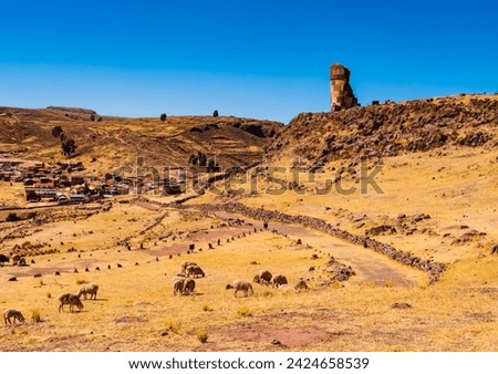 Panoramic view of Sillustani archeological site with its tallest chullpa (funerary tower) and the touristic village in background, Puno region, Peru