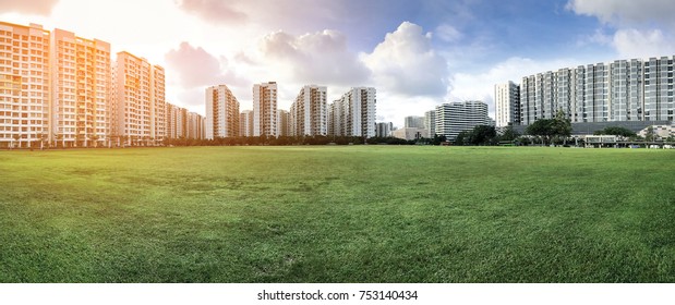 Panoramic view of Singapore Public Housing Apartments in Punggol District, Singapore. Housing and Development Board(HDB) on green grass field with sunlight effect. Punggol is planning area & new town