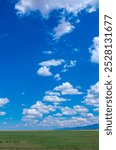 Panoramic view of sky with clouds over green field. Beautiful landscape with fluffy clouds.