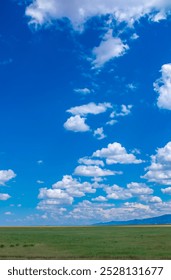 Panoramic view of sky with clouds over green field. Beautiful landscape with fluffy clouds.