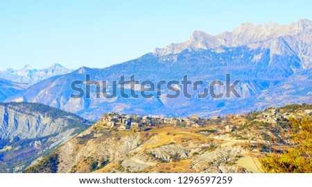 Panoramic view of a small village near Lac de Serre-Poncon in the french Alps on a clear day. Ecrins massif