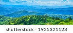 A panoramic view of the Smoky Mountains from the Blue Ridge Parkway in North Carolina. Blue sky with clouds over layers of green hills and mountains. North Carolina. Image for banner and web header.