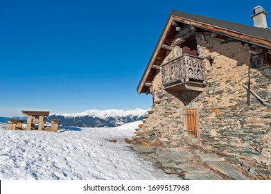 Panoramic view of snow covered slope on alpine mountain with remote stone house residence - Powered by Shutterstock