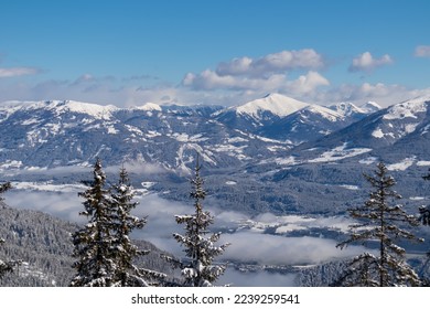 Panoramic view of the snowcapped mountain ranges of the Nock Mountains (Nockberge) seen from Kobesnock near Bad Bleiberg, Carinthia, Austria, Europe. Rosennock in winter wonderland alpine landscape