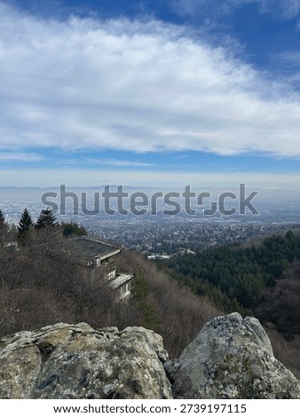 Panoramic view of Sofia city from Vitosha Mountain, Bulgaria. Urban skyline covered in atmospheric haze and air pollution. Highlighting environmental and urban living concepts. Old hut.