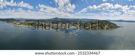 Panoramic view of the sparkling waters of Lake Coeur d'Alene with the backdrop of Coeur d'Alene, Idaho surrounded by lush forests and stunning mountain landscapes
