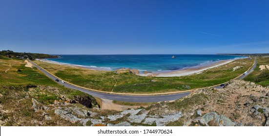 Panoramic view of St Ouens Bay wth the FiVe Mile Road, part of the sand dunes, the beach with waves and sunny blue sky. Jersey, Channel Islands, uk