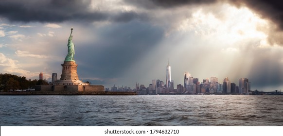 Panoramic View Of The Statue Of Liberty And Downtown Manhattan In The Background During A Vibrant Cloudy Sunrise. Taken In New York City, NY, United States.