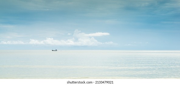 A Panoramic View Of The Still Water Surface Of The Sea Under The Blue Sky