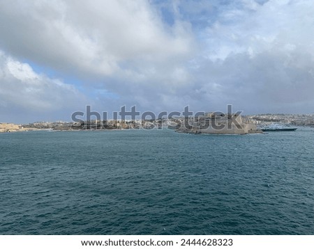 Panoramic view of three cities (Birgu (Vittoriosa), Bormla (Conspicua), Senglea) skyline with St. Angelo fort. Heavy Mediterranean sea waves at Grand harbour. View from Valletta, Malta