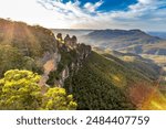 A panoramic view of the Three Sisters rock formation in the Blue Mountains, Australia. The photo was taken from the scenic Echo Point Lookout overlooking the vast mountain landscape.