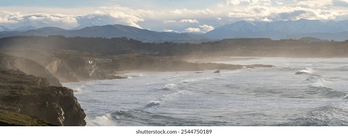 Panoramic view from the top of the cliffs at the north atlantic coastline of Spain at sunset with misty atmosphere