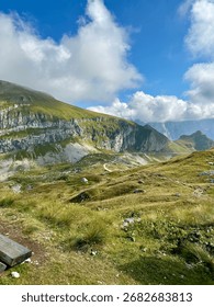 Panoramic view from the top of the highest paved road in Slovenia at Mangart Saddle, overlooking the Julian Alps and alpine landscape.