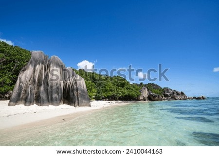 Panoramic View of Tranquil Seychelles Beach with Blue Sky and Crystal Clear Water