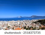 Panoramic view of trees, a bay and the houses of the city of Patras in Greece on the Peloponnese peninsula. Sightseeing and vacation in Greece. 