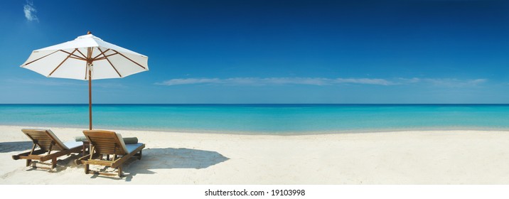 Panoramic view of two chairs and white umbrella on the beach. Banner, lots of copy space - Powered by Shutterstock